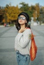 Portrait of a woman in sunglasses holding a string bag and paper cup of coffee Royalty Free Stock Photo