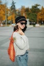 Portrait of a woman in sunglasses holding a string bag and paper cup of coffee Royalty Free Stock Photo