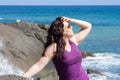 woman with sunglasses posing on the beach and leaning on rocks Royalty Free Stock Photo