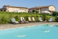 Woman with sunglasses relaxes lying on a lounger by the pool of a resort in the countryside of Pisa, Tuscany, Italy