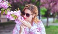 Woman in sunglasses smelling cherry tree blossom Royalty Free Stock Photo