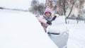 Woman in sunglasses standing near open front door of a car under snow Royalty Free Stock Photo