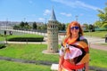 Woman in sunglasses standing near the small Galata Tower in the Istanbul park of miniature background