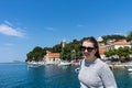 Woman with sunglasses traveler in yachts port near old town. Concept of student travel, summer vacation, solo female tourism, Royalty Free Stock Photo