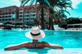 Woman with sunhat relaxing in swimming pool at spa resort. Royalty Free Stock Photo