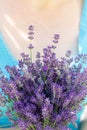 Woman on a sunny day holding a bouquet of fresh fragrant lavender. Rustic style.