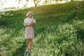 a woman at sunset in a field of dandelions in a pink dress Royalty Free Stock Photo