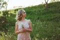 a woman at sunset in a field of dandelions in a pink dress Royalty Free Stock Photo