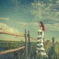 Woman at sunset meadow fence