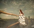 Woman at sunset meadow fence