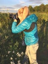 Woman at sunset photographs a grass on the fringe of the forest Royalty Free Stock Photo