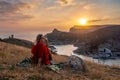 Woman sunset sea mountains. Happy woman siting with her back on the sunset in nature summer posing with mountains on Royalty Free Stock Photo