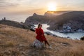 Woman sunset sea mountains. Happy woman siting with her back on the sunset in nature summer posing with mountains on Royalty Free Stock Photo