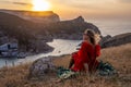 Woman sunset sea mountains. Happy woman siting with her back on the sunset in nature summer posing with mountains on Royalty Free Stock Photo