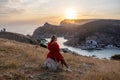 Woman sunset sea mountains. Happy woman siting with her back on the sunset in nature summer posing with mountains on Royalty Free Stock Photo