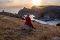 Woman sunset sea mountains. Happy woman siting with her back on the sunset in nature summer posing with mountains on Royalty Free Stock Photo