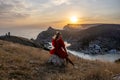 Woman sunset sea mountains. Happy woman siting with her back on the sunset in nature summer posing with mountains on Royalty Free Stock Photo