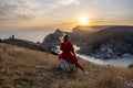 Woman sunset sea mountains. Happy woman siting with her back on the sunset in nature summer posing with mountains on Royalty Free Stock Photo