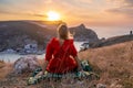 Woman sunset sea mountains. Happy woman siting with her back on the sunset in nature summer posing with mountains on Royalty Free Stock Photo