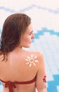 Woman With Suntan Lotion At The Beach In Form Of The Sun. Portrait Of Female With the Drawn Sun On a Shoulder On The Pool Royalty Free Stock Photo