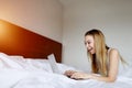 Woman super happy with laptop working home remotely at white bed