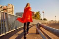 Woman super-hero runner in a red raincoat jogs.