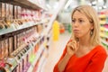 Woman in supermarket aisle looking at products