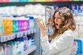 young woman in shock from the composition of baby shampoo, emotion of unpleasant surprise. the woman in the supermarket Royalty Free Stock Photo