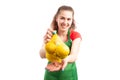 Woman supermarket or retail worker offering bag of lemons