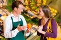 Woman in supermarket and shop assistant