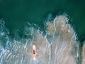 Woman surfer paddling alone in the ocean