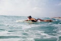 Woman surfer swimming in sea