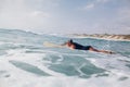 Woman surfer swimming in sea