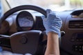 Woman in surgical face mask and gloves driving car