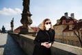 Woman with the surgical mask in the empty Charles Bridge