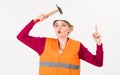 Woman with surprised face knocks with hammer on head,