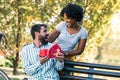 Woman Surprises man With Gift in the park Royalty Free Stock Photo