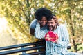 Woman Surprises man With Gift in the park Royalty Free Stock Photo