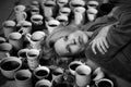 Woman surrounded by many cups of coffee, deadline concept. Workaholism, overtime, the need to be alert. Tired woman. Black and