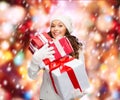 Woman in sweater and hat with many gift boxes