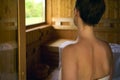 Woman sweating in Finnish sauna. Relaxing in wellness spa Royalty Free Stock Photo