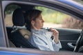 Woman driver sweating in heat blowing on chest, broken air conditioner in car in summer. Royalty Free Stock Photo