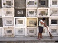 A woman sweeps in front of columns of graves in a cemetery in Antipolo City, Philippines