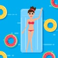 Woman in swim suit lying on floating swimming pool mattress with fruits rubber ring. Summer vacation