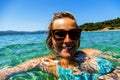 Woman swiming in the sea on tropical island, smiling at camera w Royalty Free Stock Photo