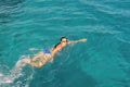 Woman swimmer swimming crawl in blue sea. Woman swiming in the sea. Happy young woman in a blue swimsuit in the sea on vacation. Royalty Free Stock Photo