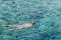 Woman swimming in blue sea. Snorkeling girl in full-face snorkeling mask. Coral reef in shallow sea. Snorkel undersea. Seashore Royalty Free Stock Photo