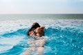 Woman swimming crawl in a pool with ocean view