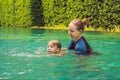 Woman swimming instructor for children is teaching a happy boy to swim in the pool Royalty Free Stock Photo