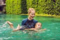 Woman swimming instructor for children is teaching a happy boy to swim in the pool Royalty Free Stock Photo